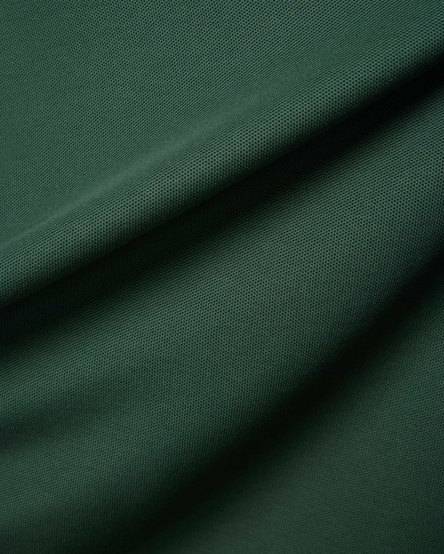 Deep forest green Mens Classic Pique Polo fabric, highlighting the signature textured pique weave with elegant folds and shadows, reflecting Psycho Bunny's premium quality and refined streetwear style.