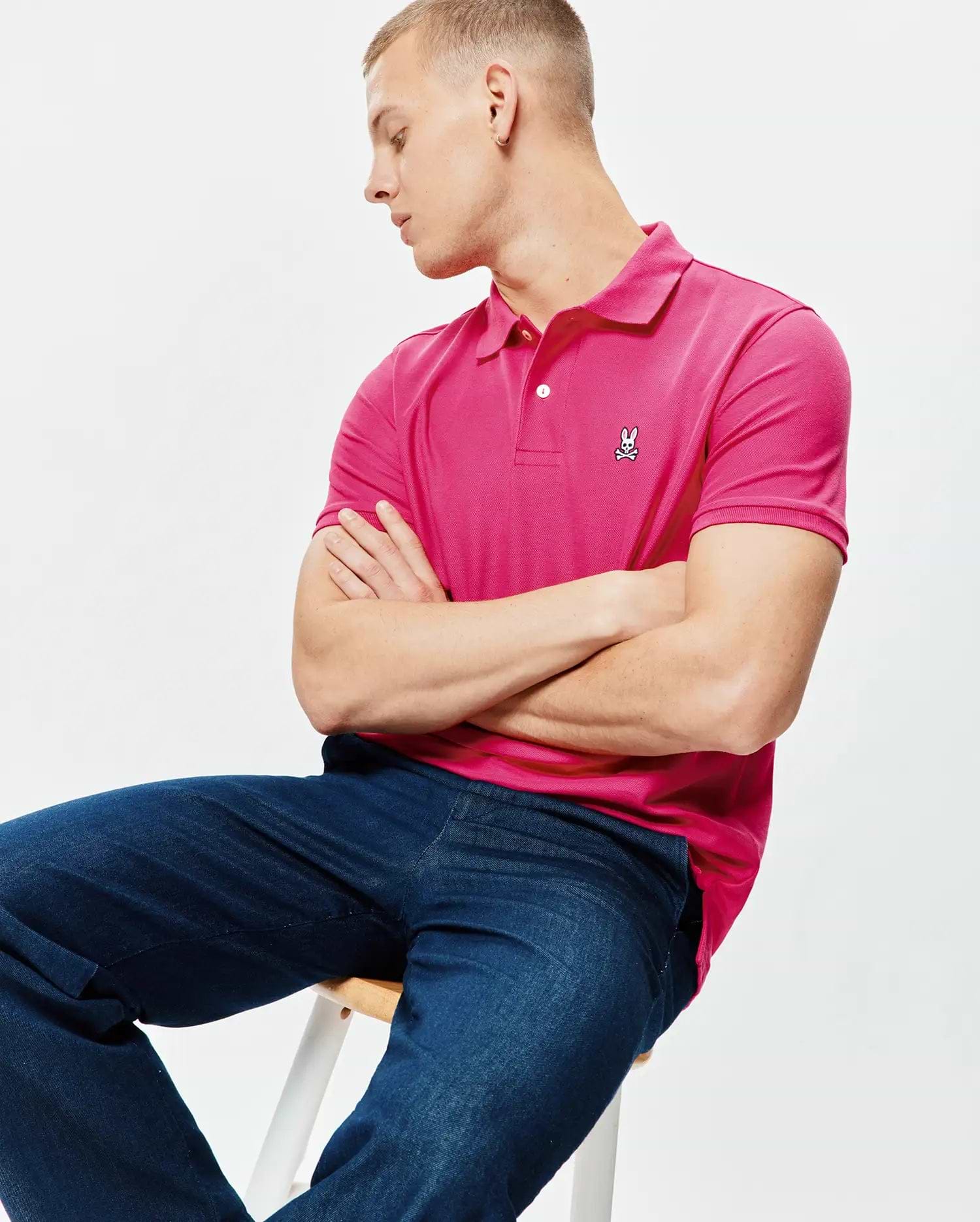 Mens Classic Pique Polo in vibrant fuchsia, featuring a classic fit, textured pique knit fabric, two white button placket, and a small embroidered white Psycho Bunny skull logo on the left chest. (4)