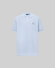 The Psycho Bunny MENS CLASSIC PIQUE POLO (B6K001F200) is a light blue short-sleeved Pima cotton men’s polo with a collar, two buttons, and an embroidered bunny logo on the left chest, shown on a plain gray background.