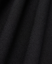Close-up of the black Pima cotton fabric under soft lighting, showcasing the fine weave and subtle folds of Psycho Bunny's MENS JAMES PREMIUM PIQUE POLO SHIRT - B6K945D200. The surface appears smooth and uniform, with shadows emphasizing the gentle undulations typical of this high-quality polo shirt.