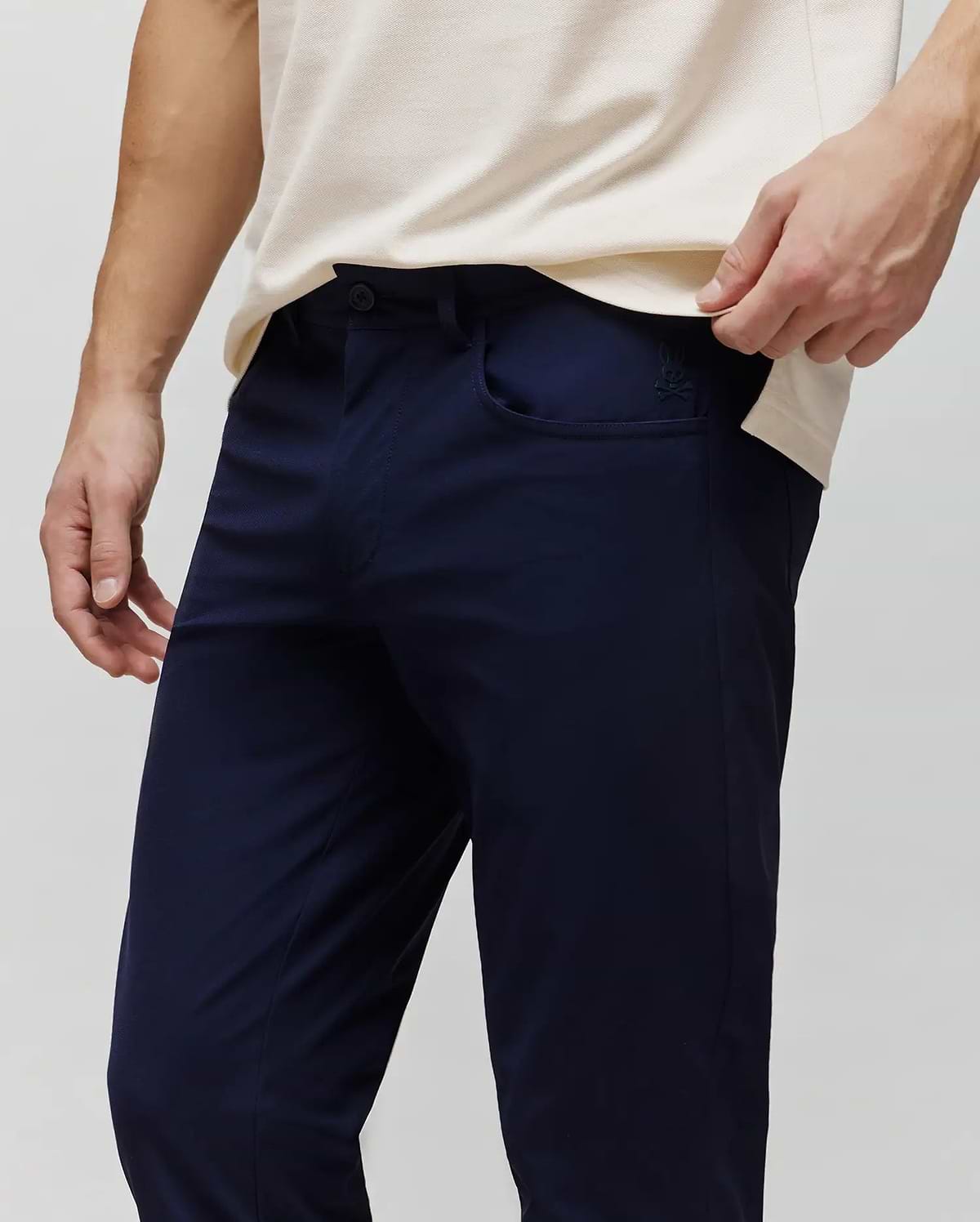 Mens Maverick 10k Step Pant in navy blue, featuring a slim fit and smooth performance fabric. A small, embroidered Psycho Bunny skull logo is visible on the right front pocket. (2)