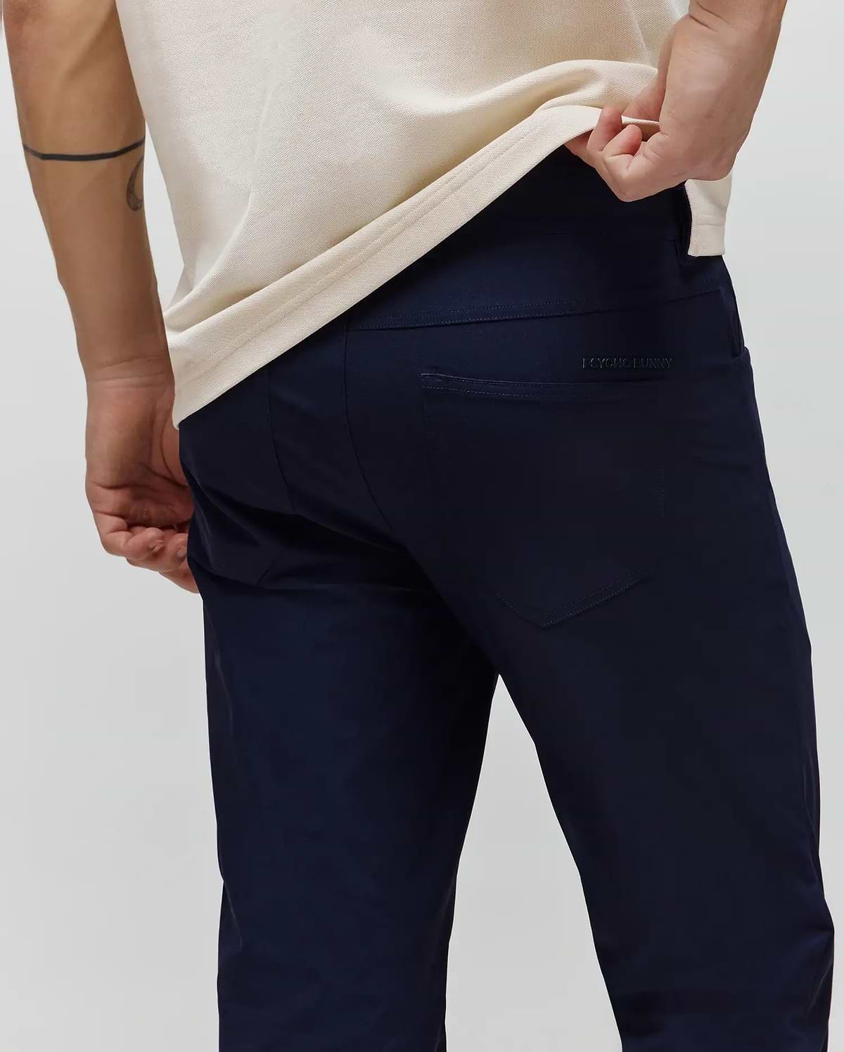 Mens Maverick 10k Step Pant in deep navy, featuring a refined slim fit and smooth performance fabric. A subtle, tonal Psycho Bunny text logo is embroidered on the right back pocket. (3)
