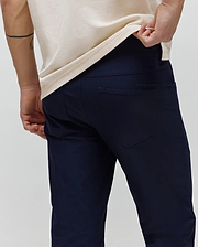 Mens Maverick 10k Step Pant in deep navy, featuring a refined slim fit and smooth performance fabric. A subtle, tonal Psycho Bunny text logo is embroidered on the right back pocket. (3)