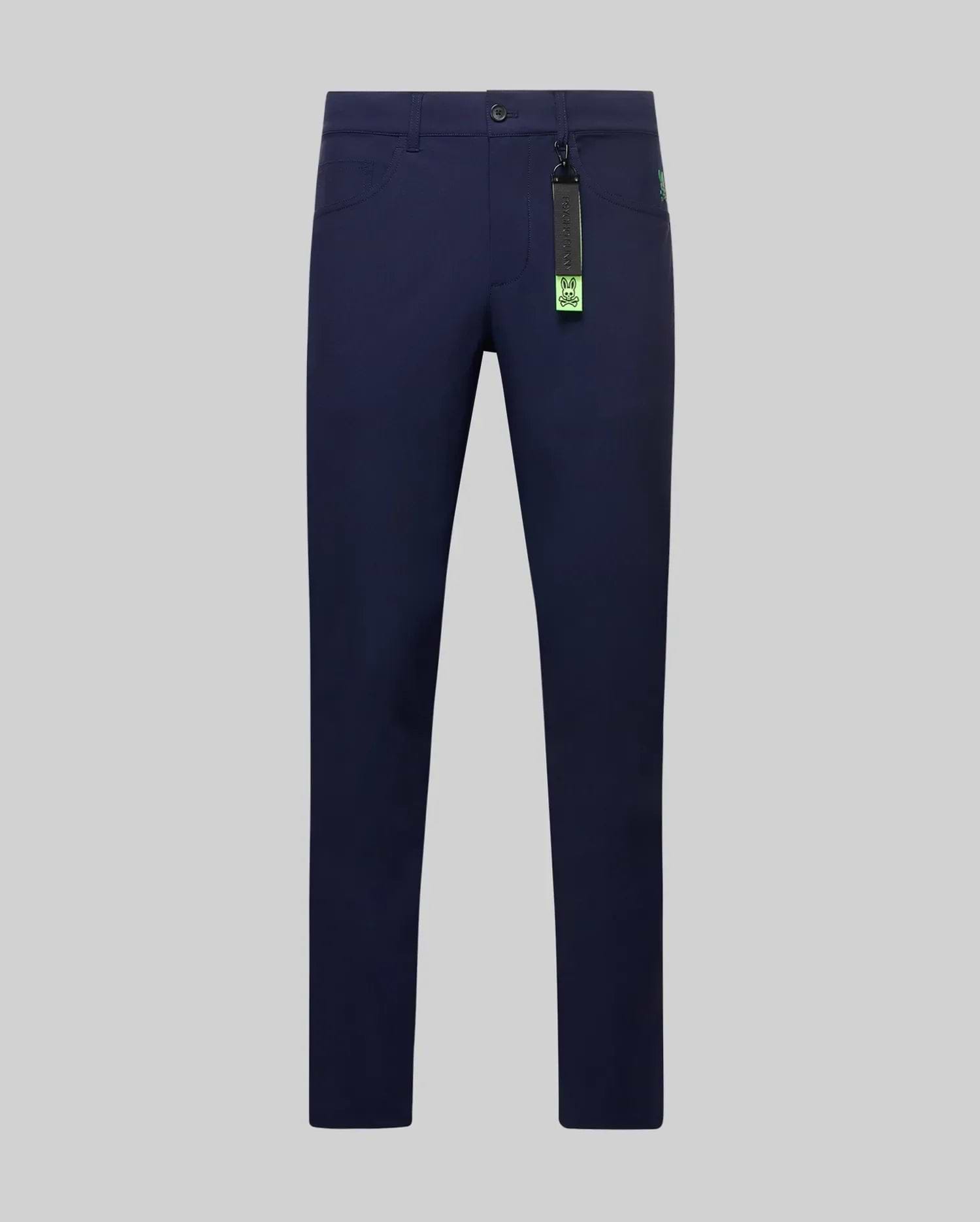 Mens Maverick 10k Step Pant in navy blue, a slim-fit style with smooth performance fabric, featuring a small neon green embroidered Psycho Bunny skull logo on the front pocket and a vibrant brand tag. (5)