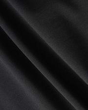 Close-up of a dark fabric with diagonal folds, showcasing a smooth texture and subtle sheen under light, reminiscent of the material in the Psycho Bunny MENS MAVERICK 10K PANT - B6P788D200. The fabric appears to be made of a fine, tightly woven material with impressive four-way stretch capabilities.