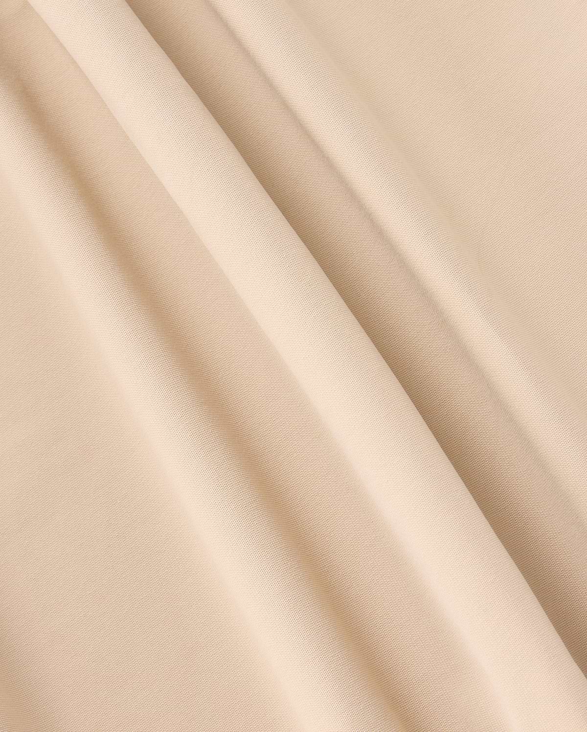A close-up photograph of beige-colored fabric with a soft, smooth texture. The fabric, similar to that of the Psycho Bunny Mens Maverick 10K Pant (B6P788D200), is draped in gentle folds, creating light and shadow variations across its surface.