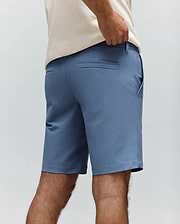 Slate blue Mens Maverick 10k Step Short, a classic fit performance fabric short with back welt pockets and a small embroidered Psycho Bunny text logo on the right rear pocket.