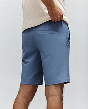 Slate blue Mens Maverick 10k Step Short, a classic fit performance fabric short with back welt pockets and a small embroidered Psycho Bunny text logo on the right rear pocket.