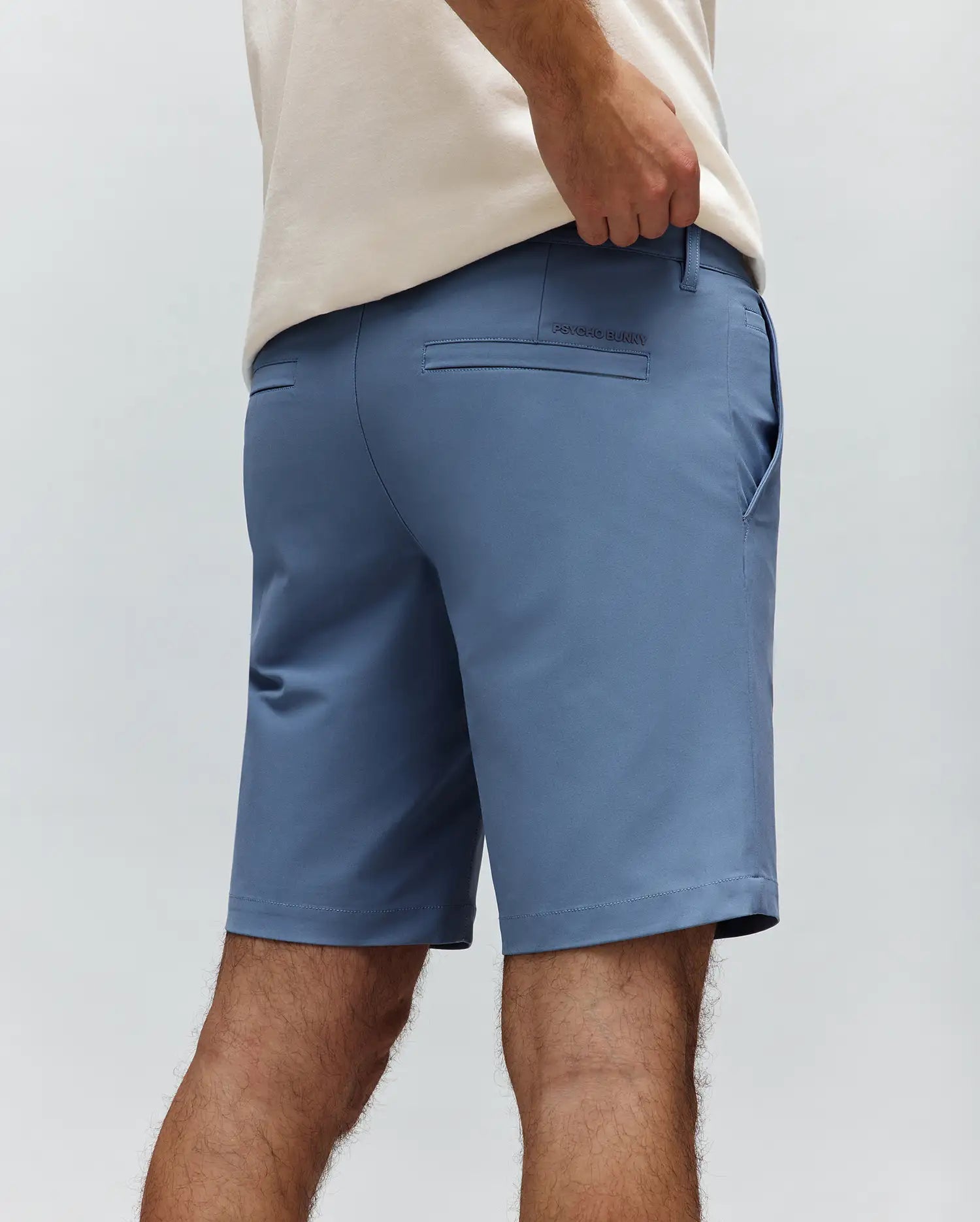 Slate blue Mens Maverick 10k Step Short, a classic fit performance fabric short with back welt pockets and a small embroidered Psycho Bunny text logo on the right rear pocket.