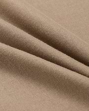 A close-up of beige fabric with a smooth texture shows soft folds and gentle shadows. Resembling the lightweight, finely woven 100% Pima cotton in the MENS CLASSIC CREW NECK TEE - B6U014CRPC by Psycho Bunny, it highlights its delicate and even surface.