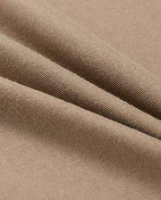 A close-up of beige fabric with a smooth texture shows soft folds and gentle shadows. Resembling the lightweight, finely woven 100% Pima cotton in the MENS CLASSIC CREW NECK TEE - B6U014CRPC by Psycho Bunny, it highlights its delicate and even surface.