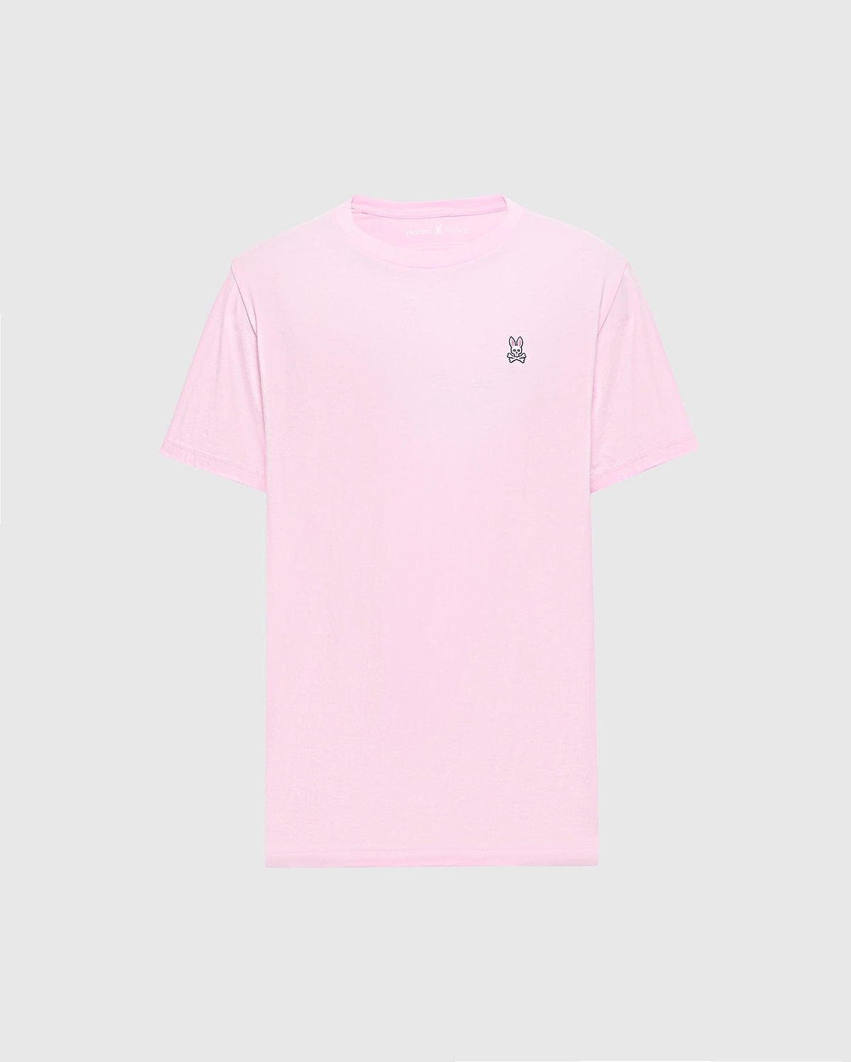 The Psycho Bunny MENS CLASSIC CREW NECK TEE - B6U014CRPC features a light pink color with short sleeves and a small embroidered peace sign on the upper left. Made from soft Pima cotton in a regular fit, it's shown on a plain gray background.