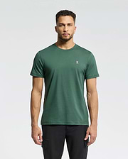 A man faces forward against a light gray background, wearing Psycho Bunny's MENS CLASSIC CREW NECK TEE - B6U014F200 in dark green with a small white rabbit logo on the left chest, paired with black pants.