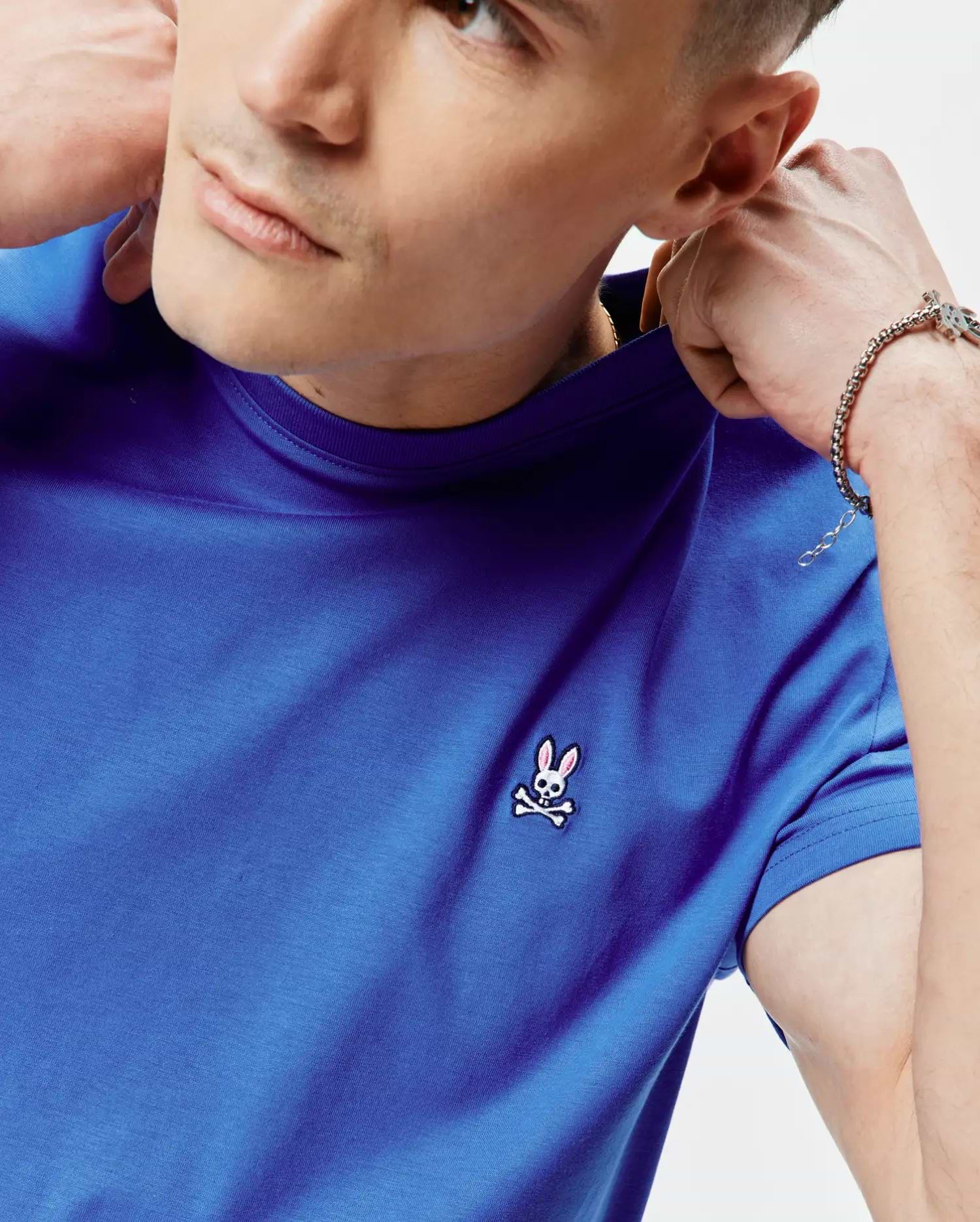 Mens Classic Crew Neck Tee in royal blue, featuring a classic fit and smooth jersey fabric. Small embroidered Psycho Bunny skull logo with pink ears and white crossbones on the left chest.