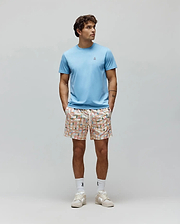 Mens Classic Crew Neck Tee in light blue jersey with a small embroidered Psycho Bunny logo on the left chest, paired with cream woven shorts featuring a multi-colored grid pattern and integrated bunny skull logos. (5)