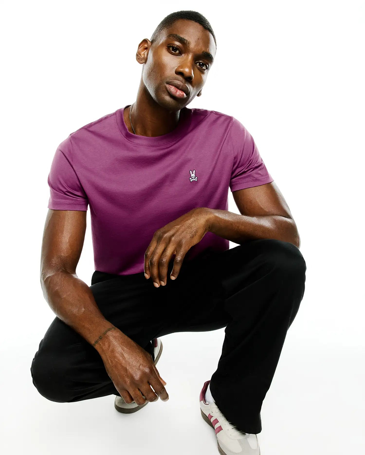 Mens Classic Crew Neck Tee in rich purple, crafted from smooth jersey fabric with a classic fit. Features a small, embroidered white and black Psycho Bunny skull logo on the left chest.