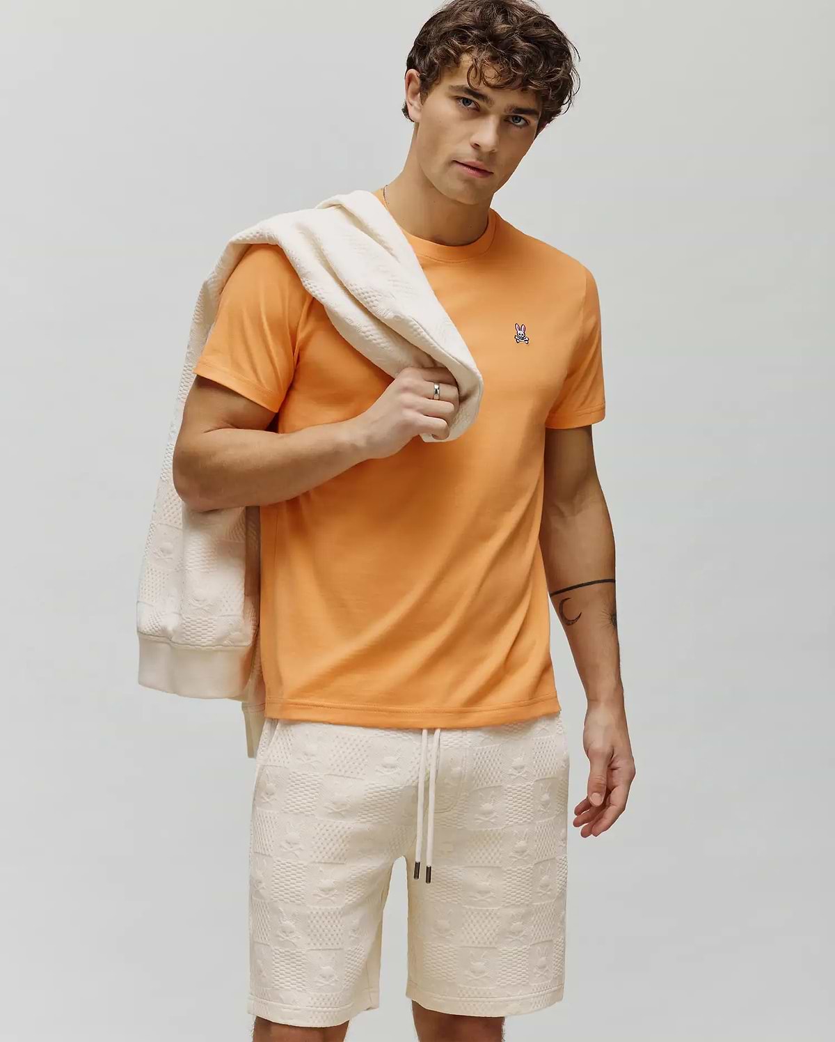 Vibrant Orange Mens Classic Crew Neck Tee, classic fit, soft jersey, featuring a small, embroidered Psycho Bunny skull logo with white, pink, and black details on the left chest. (4)