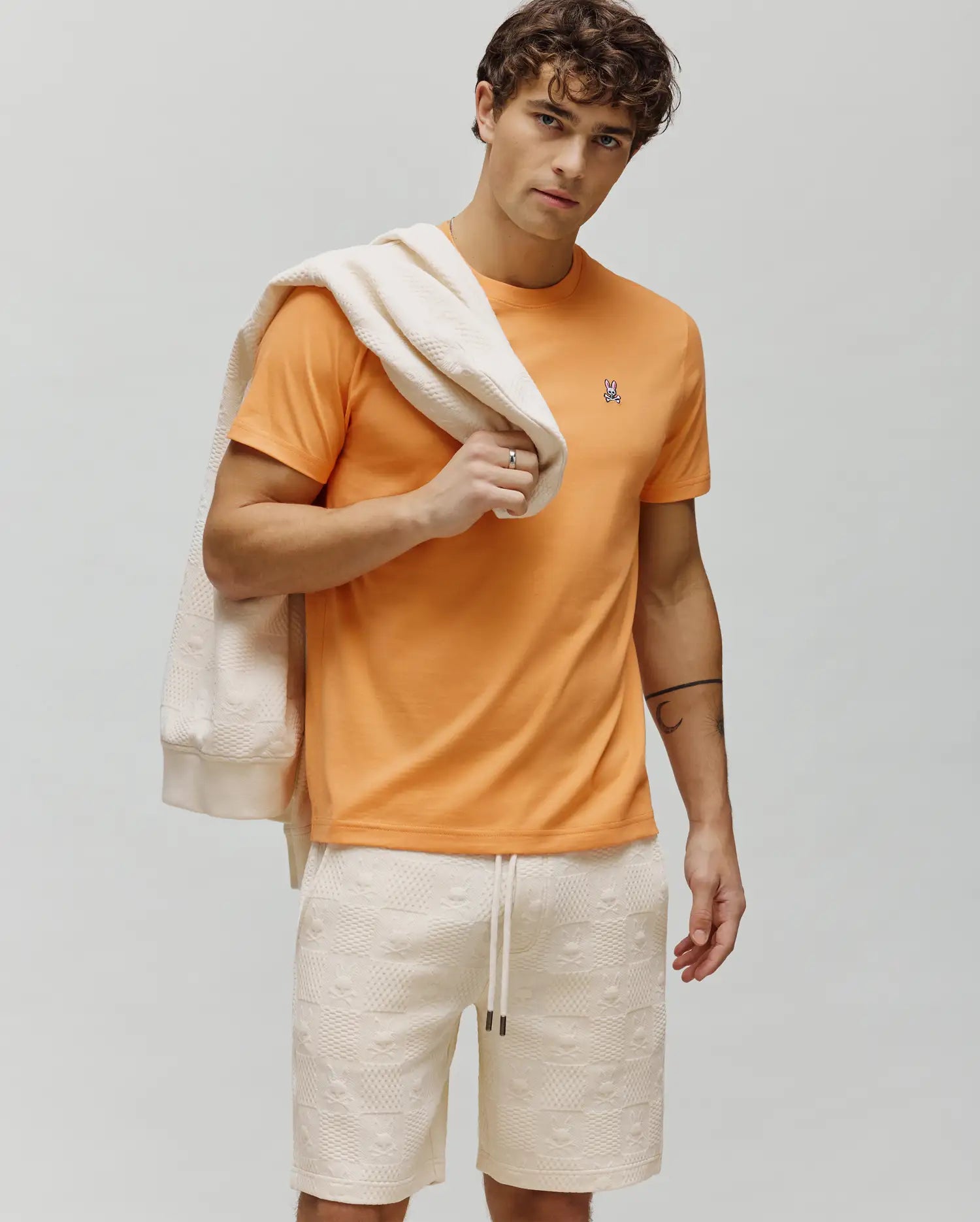 Vibrant Orange Mens Classic Crew Neck Tee, classic fit, soft jersey, featuring a small, embroidered Psycho Bunny skull logo with white, pink, and black details on the left chest. (4)
