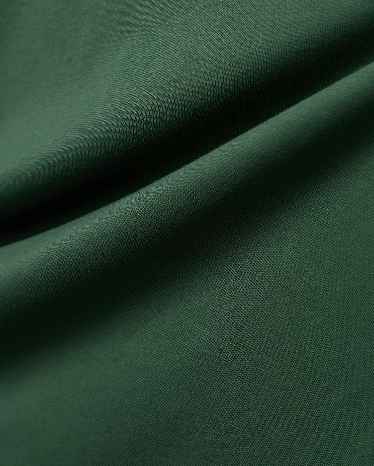 Mens Classic Crew Neck Tee in rich, deep forest green, crafted from premium, soft-touch jersey fabric, showcasing a refined, subtle knit texture and elegant, flowing drapes.