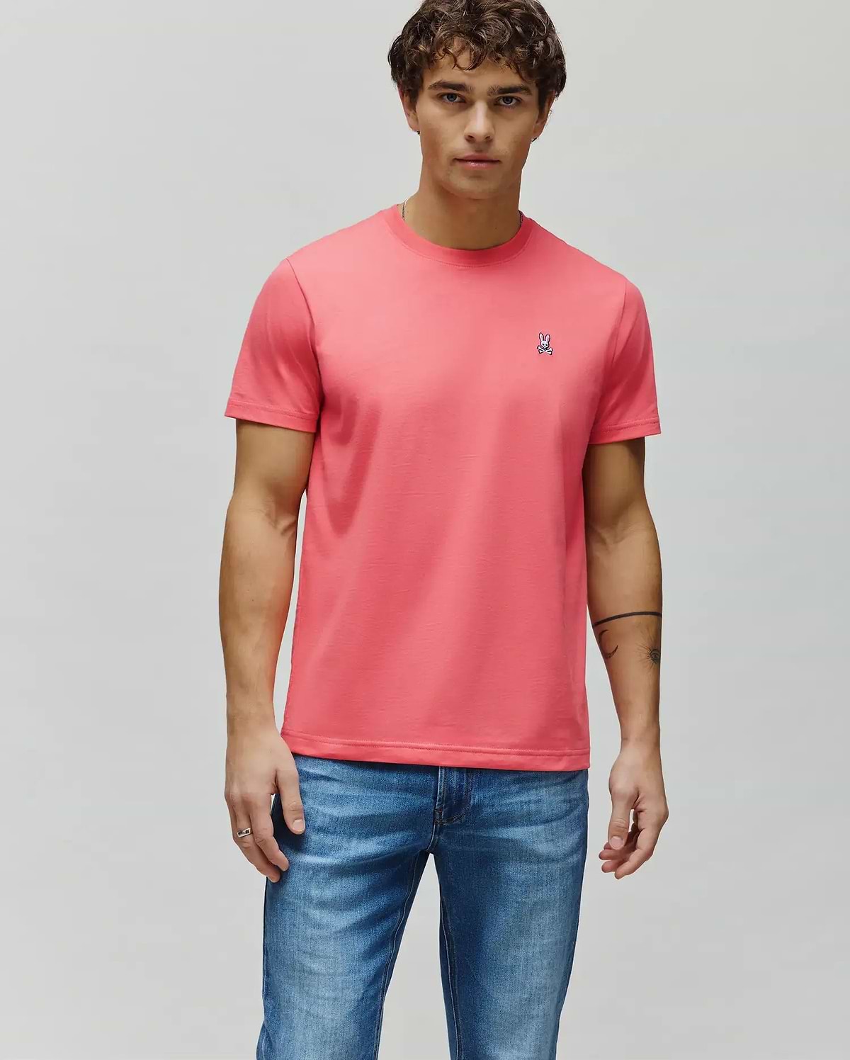 Mens Classic Crew Neck Tee in coral, featuring a classic fit and soft jersey knit fabric. Small embroidered Psycho Bunny skull logo on the left chest with white, black, and pink details. (4)