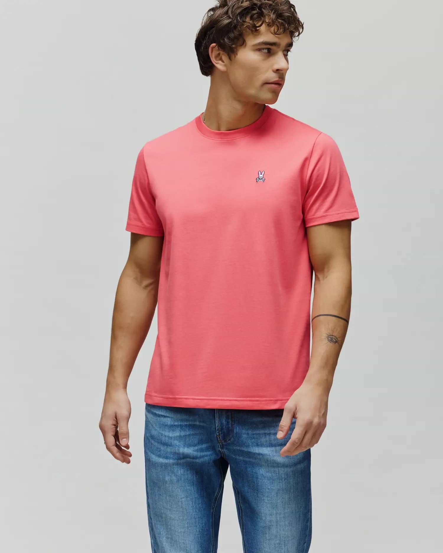 Mens Classic Crew Neck Tee in vibrant coral, featuring a smooth jersey knit and a classic fit. Small embroidered Psycho Bunny skull logo with white, blue, and red accents on the left chest. (1)