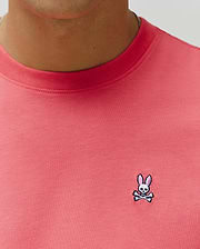 Mens Classic Crew Neck Tee in vibrant coral jersey knit, featuring a classic fit and a small, embroidered Psycho Bunny skull logo with pink ears on the left chest. (3)