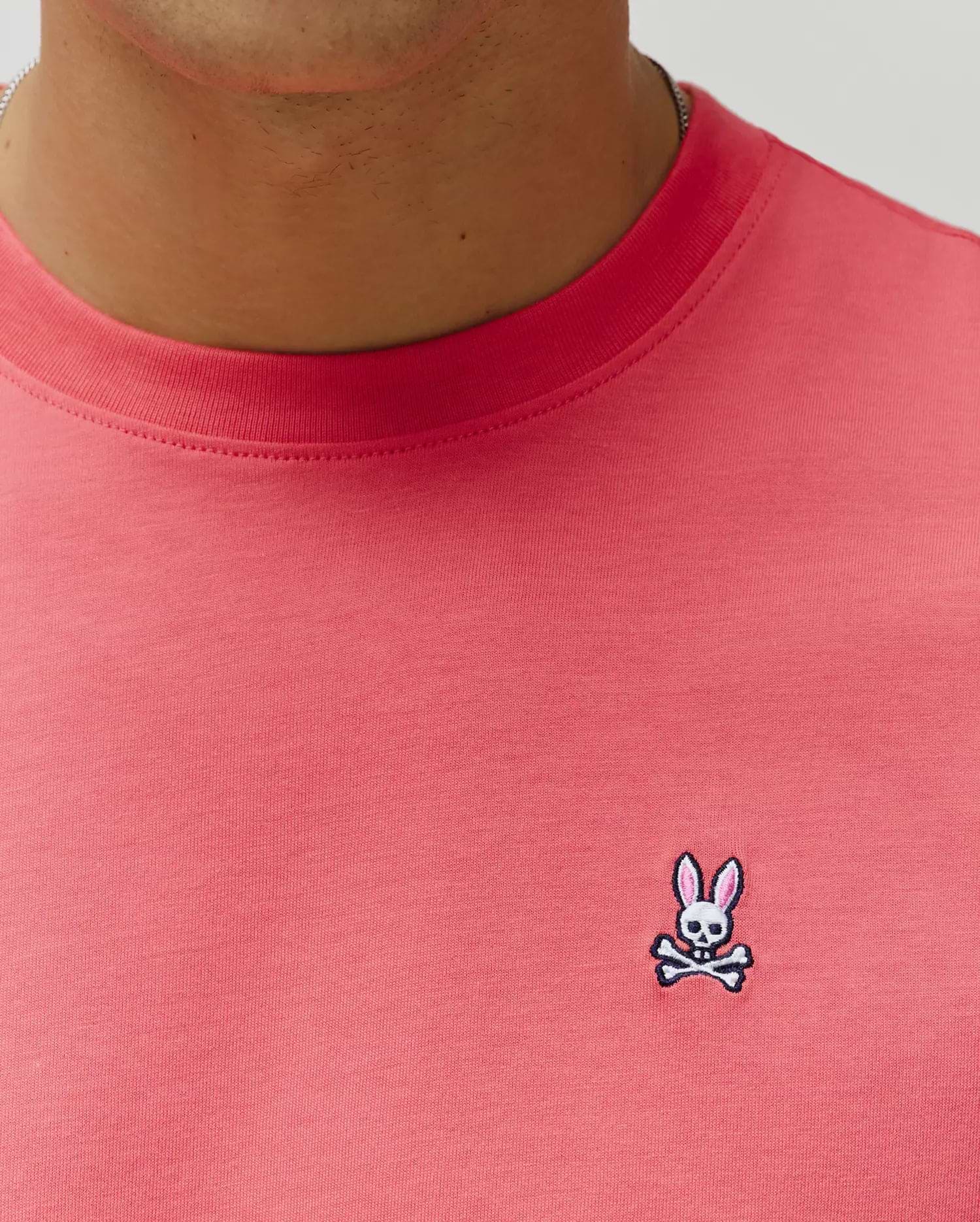 Mens Classic Crew Neck Tee in vibrant coral jersey knit, featuring a classic fit and a small, embroidered Psycho Bunny skull logo with pink ears on the left chest. (3)