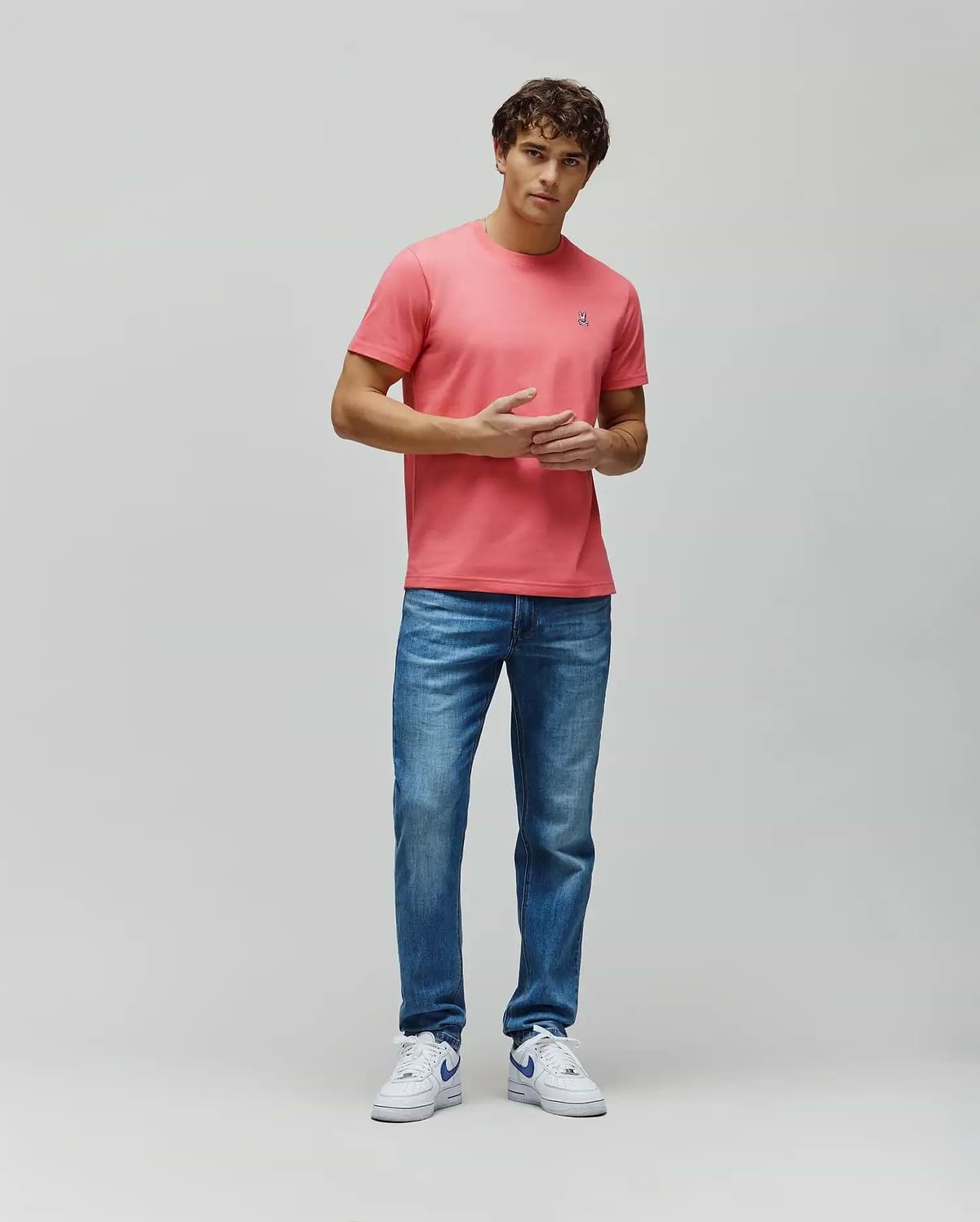 Mens Classic Crew Neck Tee in coral pink, featuring a classic fit, soft jersey fabric, and a small embroidered white and blue Psycho Bunny skull logo on the left chest. (5)