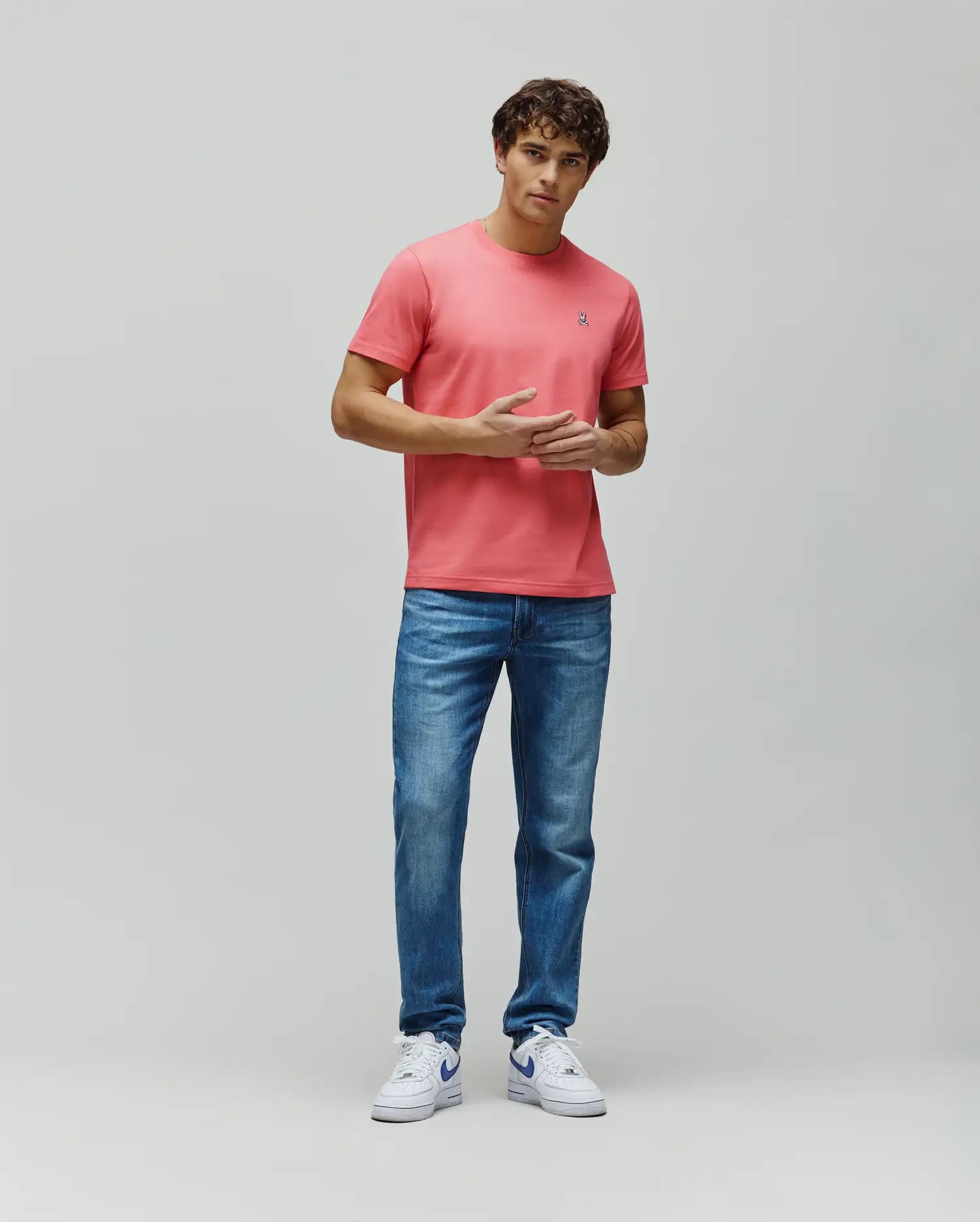 Mens Classic Crew Neck Tee in coral pink, featuring a classic fit, soft jersey fabric, and a small embroidered white and blue Psycho Bunny skull logo on the left chest. (5)