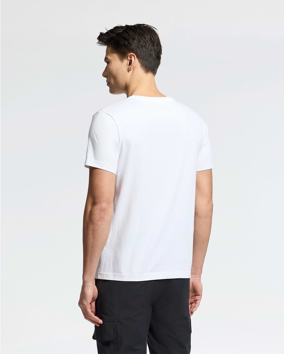 Person facing away, dressed in a Psycho Bunny MENS CLASSIC V NECK TEE - B6U100ARPC crafted from 100% Pima cotton and black pants, stands against a simple white background.