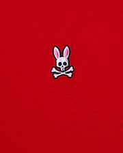 This men's v-neck tee, by Psycho Bunny, features a small emblem of a bunny skull with pink ears and crossbones embroidered on its bright red fabric. It's crafted from premium Pima cotton for exceptional quality. The product is named MENS CLASSIC V NECK TEE - B6U100CRPC.