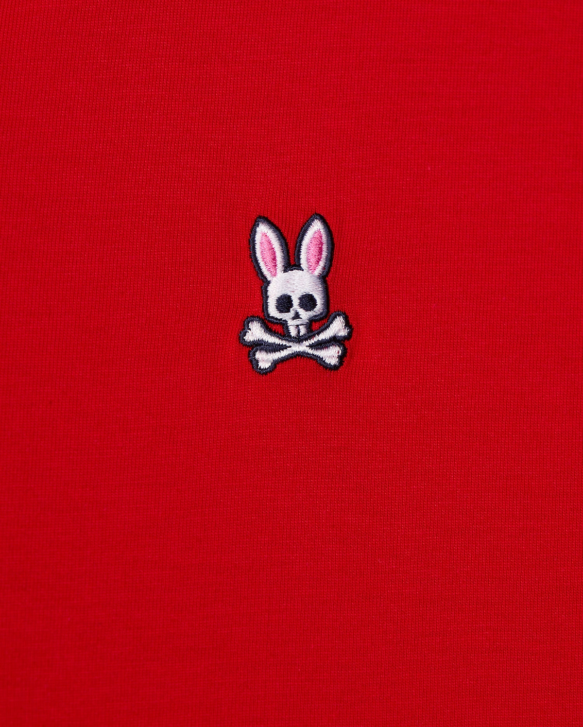 This men's v-neck tee, by Psycho Bunny, features a small emblem of a bunny skull with pink ears and crossbones embroidered on its bright red fabric. It's crafted from premium Pima cotton for exceptional quality. The product is named MENS CLASSIC V NECK TEE - B6U100CRPC.
