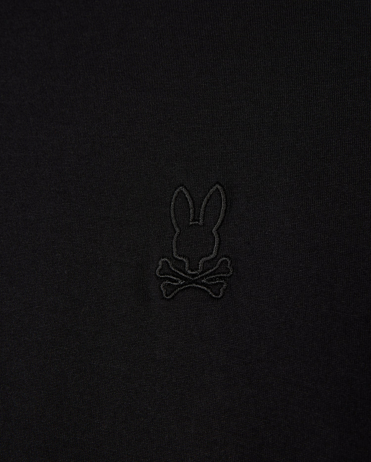 Close-up of the Psycho Bunny MENS JAMES PREMIUM CREW NECK TEE (B6U952D200), crafted from soft Pima cotton, featuring a black embroidered bunny head above crossbones logo, offering a playful twist on the traditional skull and crossbones symbol in the center.