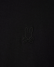 Close-up of the Psycho Bunny MENS JAMES PREMIUM CREW NECK TEE (B6U952D200), crafted from soft Pima cotton, featuring a black embroidered bunny head above crossbones logo, offering a playful twist on the traditional skull and crossbones symbol in the center.