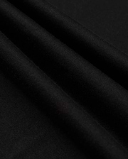 Close-up of the neatly folded black Pima cotton fabric with a soft texture. Three prominent folds create shadows, emphasizing the smooth material. The image highlights the quality and richness of Psycho Bunny's MENS JAMES PREMIUM CREW NECK TEE - B6U952D200, showcasing its sleek and elegant appearance.
