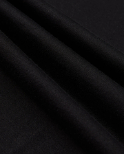 Close-up of the neatly folded black Pima cotton fabric with a soft texture. Three prominent folds create shadows, emphasizing the smooth material. The image highlights the quality and richness of Psycho Bunny's MENS JAMES PREMIUM CREW NECK TEE - B6U952D200, showcasing its sleek and elegant appearance.