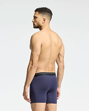 A shirtless man with short dark hair stands slightly to the side in Psycho Bunny's MENS 2 PACK BOXER BRIEF - B6V481F200. The briefs are dark blue with a black waistband and made of soft Pima cotton, set against a plain light background.