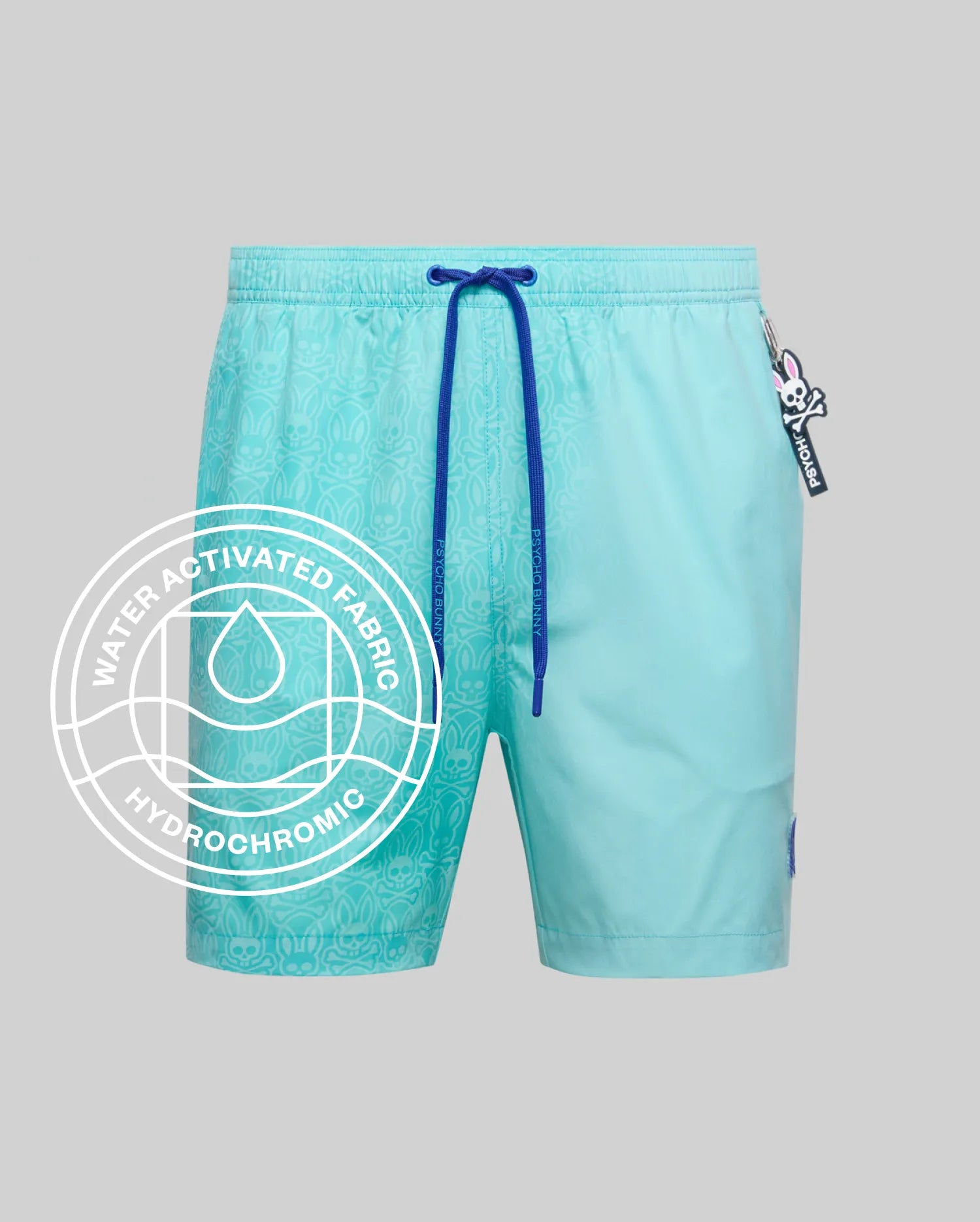 Mens Samos Hydrochromic Printed Swim Trunk in aqua, featuring a water-activated subtle Psycho Bunny skull pattern, royal blue drawstrings, and a small side logo tag.