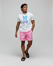 White jersey t-shirt with a large blue and pink gradient Psycho Bunny skull logo on the chest, paired with Pink Mens Samos Hydrochromic Printed Swim Trunk featuring a small black embroidered bunny logo on the left leg.