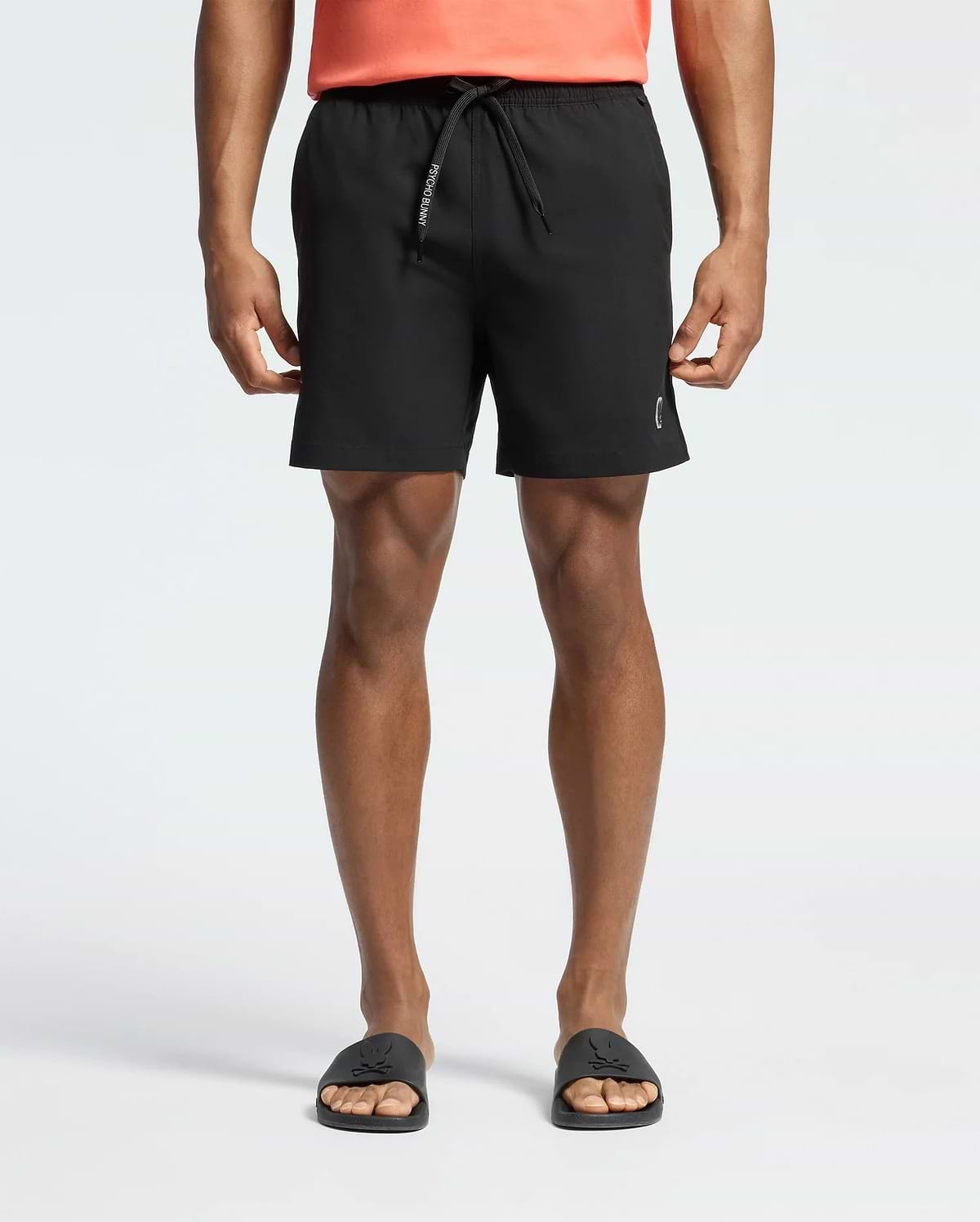 Mens Samos Hydrochromic Printed Swim Trunk in black, featuring a classic fit, smooth quick-dry fabric, a drawstring with white Psycho Bunny text, and a subtle white bunny skull logo on the lower left leg.