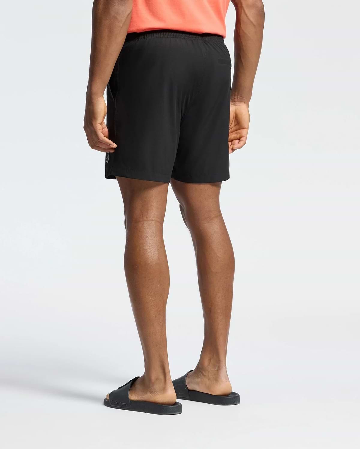 Mens Samos Hydrochromic Printed Swim Trunk in black, with a relaxed fit, smooth quick-dry fabric, elastic waistband, side zipper pockets, and a subtle white Psycho Bunny logo on the lower left leg.