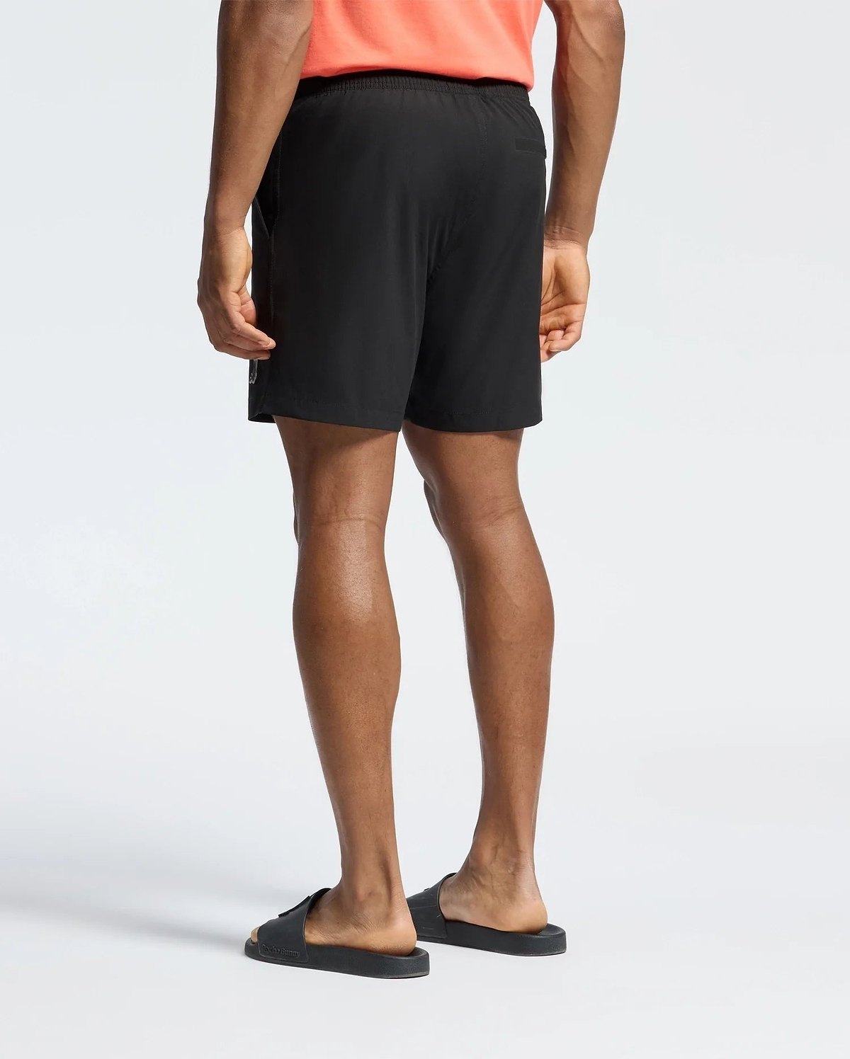 Mens Samos Hydrochromic Printed Swim Trunk in black, with a relaxed fit, smooth quick-dry fabric, elastic waistband, side zipper pockets, and a subtle white Psycho Bunny logo on the lower left leg.