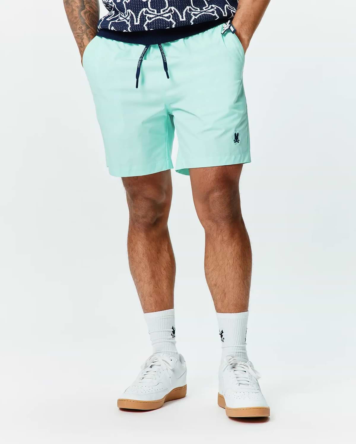 Mens Samos Hydrochromic Printed Swim Trunk 6 in mint green, featuring a relaxed fit, smooth quick-dry fabric, embroidered navy bunny skull logo on the left leg, and a navy drawstring with Psycho Bunny branding. (2)