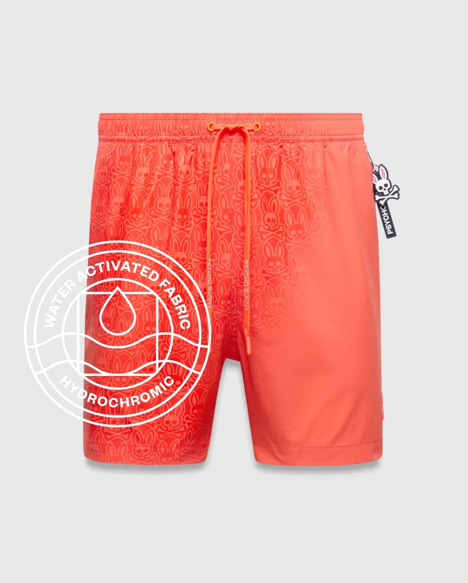 Mens Samos Hydrochromic Printed Swim Trunk, a coral orange classic fit swim short with a smooth quick-dry fabric and a water-activated all-over Psycho Bunny skull logo print.
