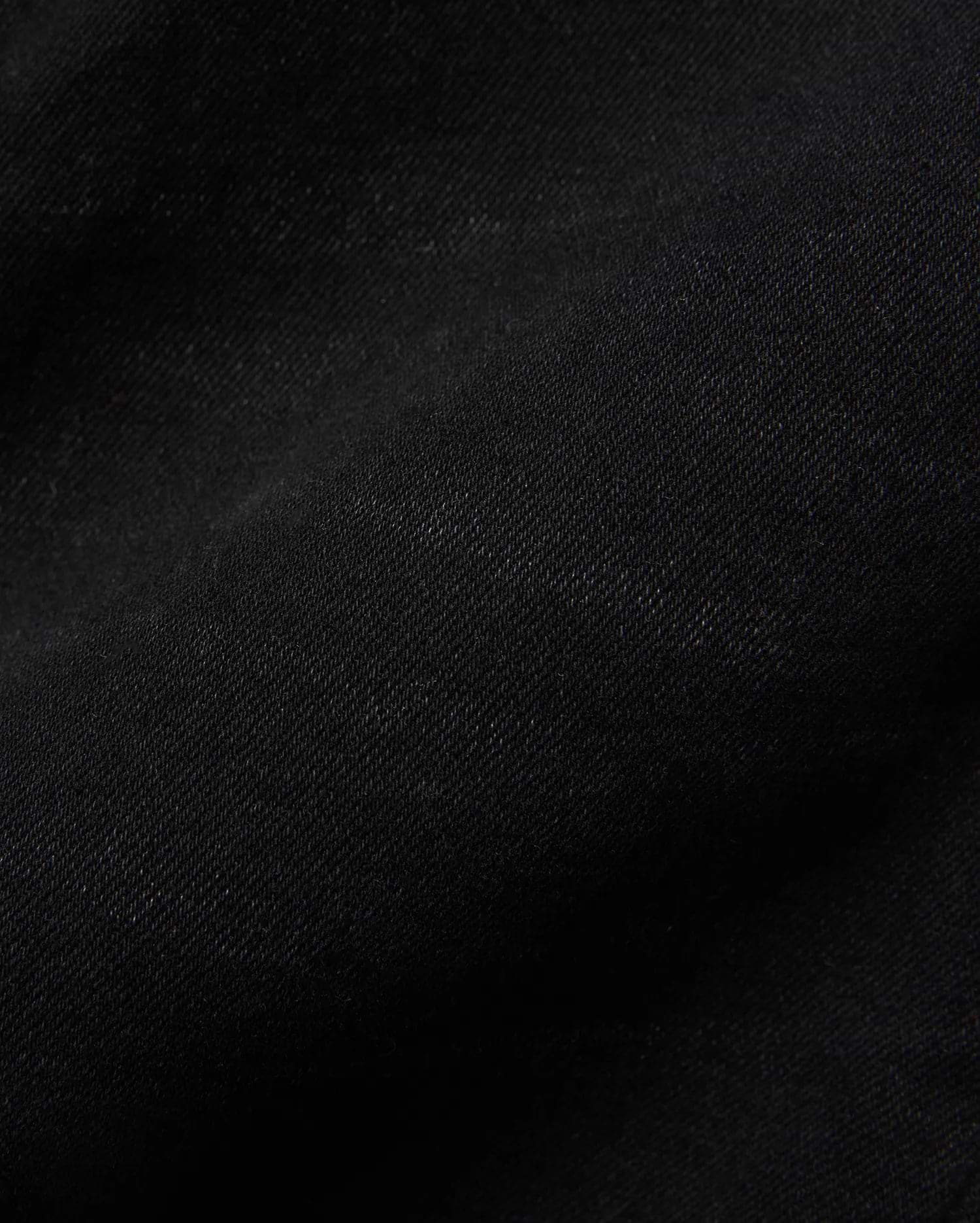 Kids Emerson Denim Pant, showcasing the rich, deep black denim fabric with a distinct diagonal twill weave texture. The premium quality material is subtly creased, highlighting its refined finish.