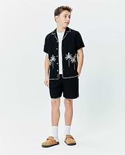 Black short-sleeve button-up shirt with white contrast stitching and palm tree embroidery, paired with matching Black Kids Brad Linen Short featuring white contrast stitching, both in a relaxed fit.