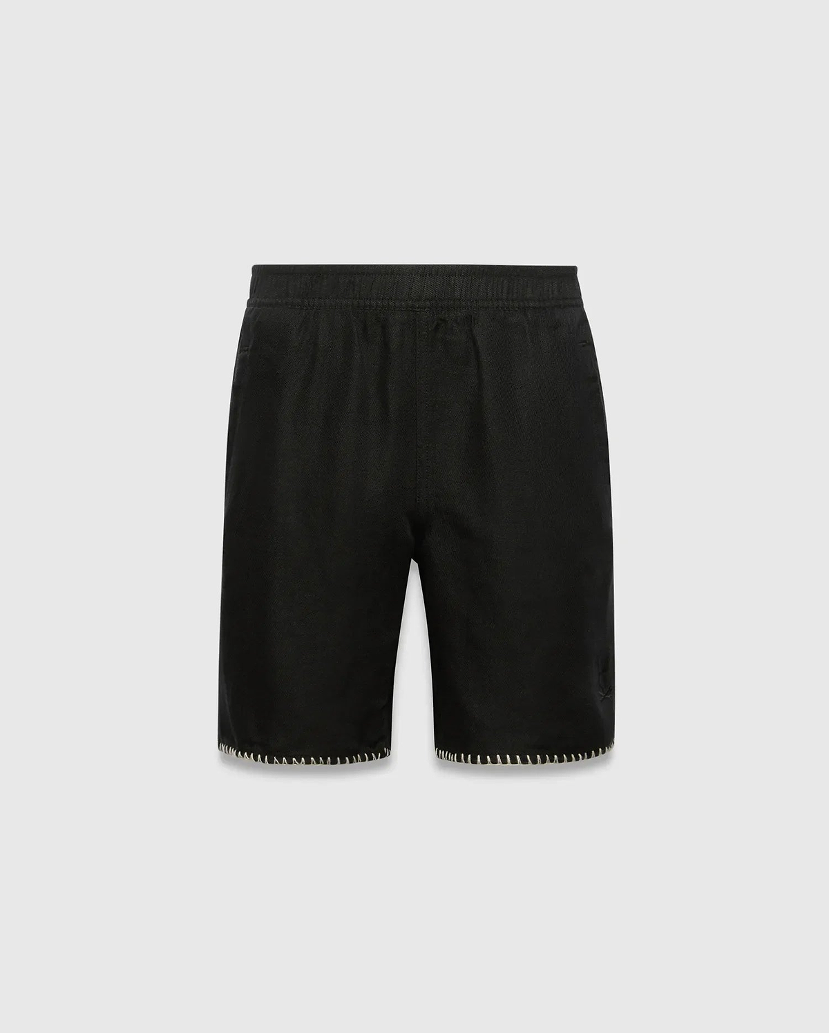 Kids Brad Linen Short, black relaxed fit with linen texture, featuring a subtle tonal embroidered Psycho Bunny skull logo on the lower right leg and white contrast blanket stitching on the hem.