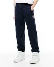 Kids Darcy Sweatpant, navy blue, relaxed fit, soft french terry with drawstring waist and ribbed cuffs. Features a small, multi-color embroidered Psycho Bunny skull logo on the left thigh.