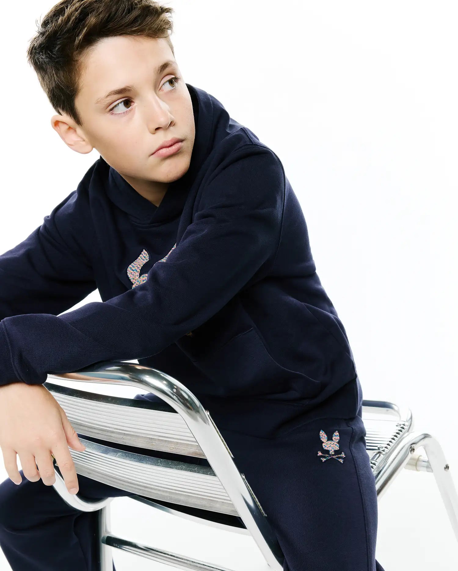 Navy relaxed fit hoodie and KIDS DARCY SWEATPANT in soft French terry, featuring a large multicolor embroidered Psycho Bunny skull logo on the hoodie chest and a smaller one on the left sweatpant thigh.