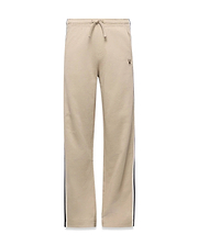 Kids Ty French Terry Sweatpant in beige, featuring a relaxed fit, drawstring waist, navy and white side stripes, and a small embroidered Psycho Bunny skull logo on the upper right thigh.